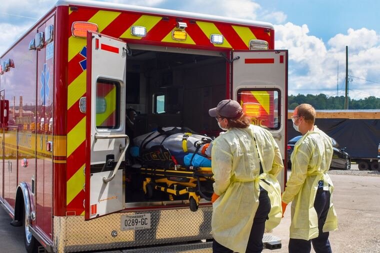 Paramedics loading a stretcher into an ambulance