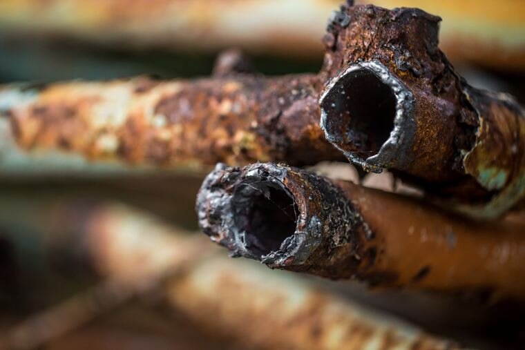 Corroded cast iron drain pipes exposed during a repair