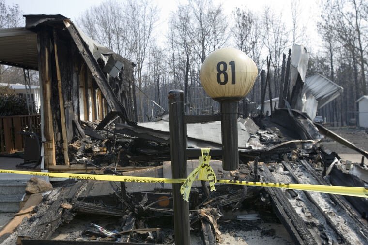 Fire-damaged structure behind caution tape
