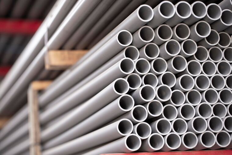 Plumber working on PVC water supply pipes inside a wall